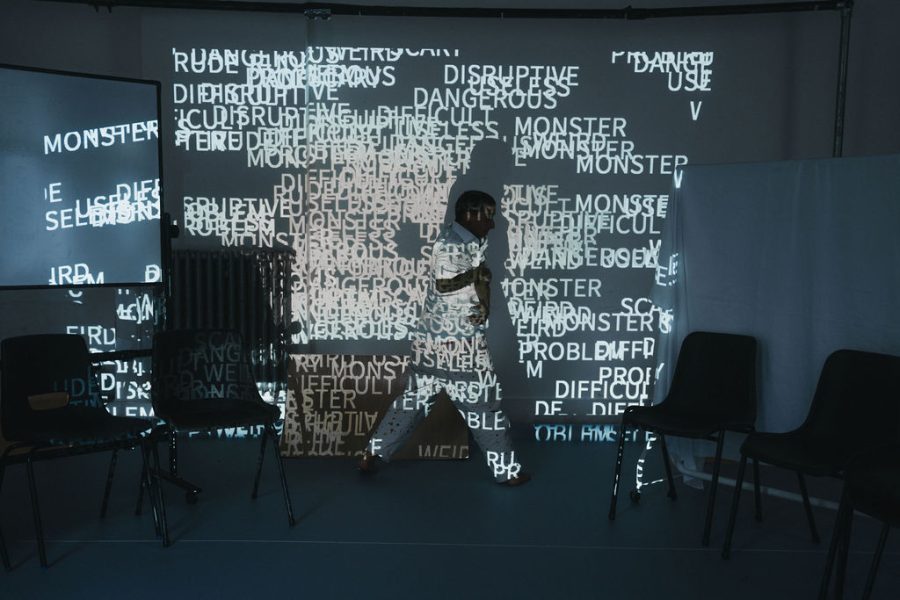 zanni CT on the set with projections of words behind them on the set of A Class of Your Own.